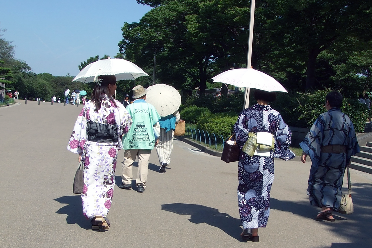 真夏の大阪城公園を浴衣姿で散策する参加者たち