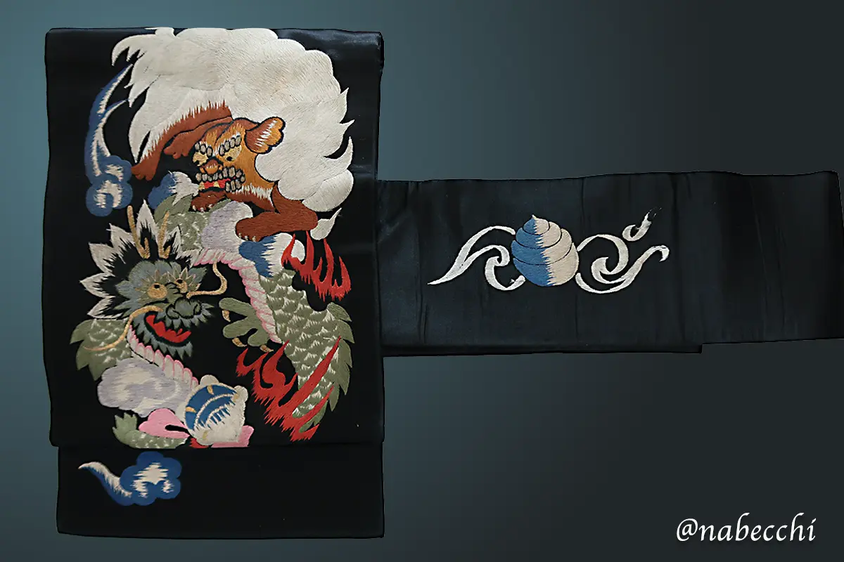 黒繻子に色鮮やかな刺繍で施された、愛嬌のある龍と獅子のアンティーク帯の全体像
