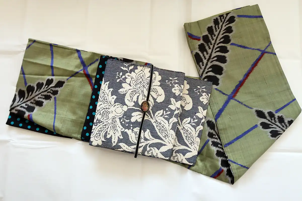 抹茶色の藤柄銘仙着物に紺地レース調の紬帯を合わせたカジュアルコーデ