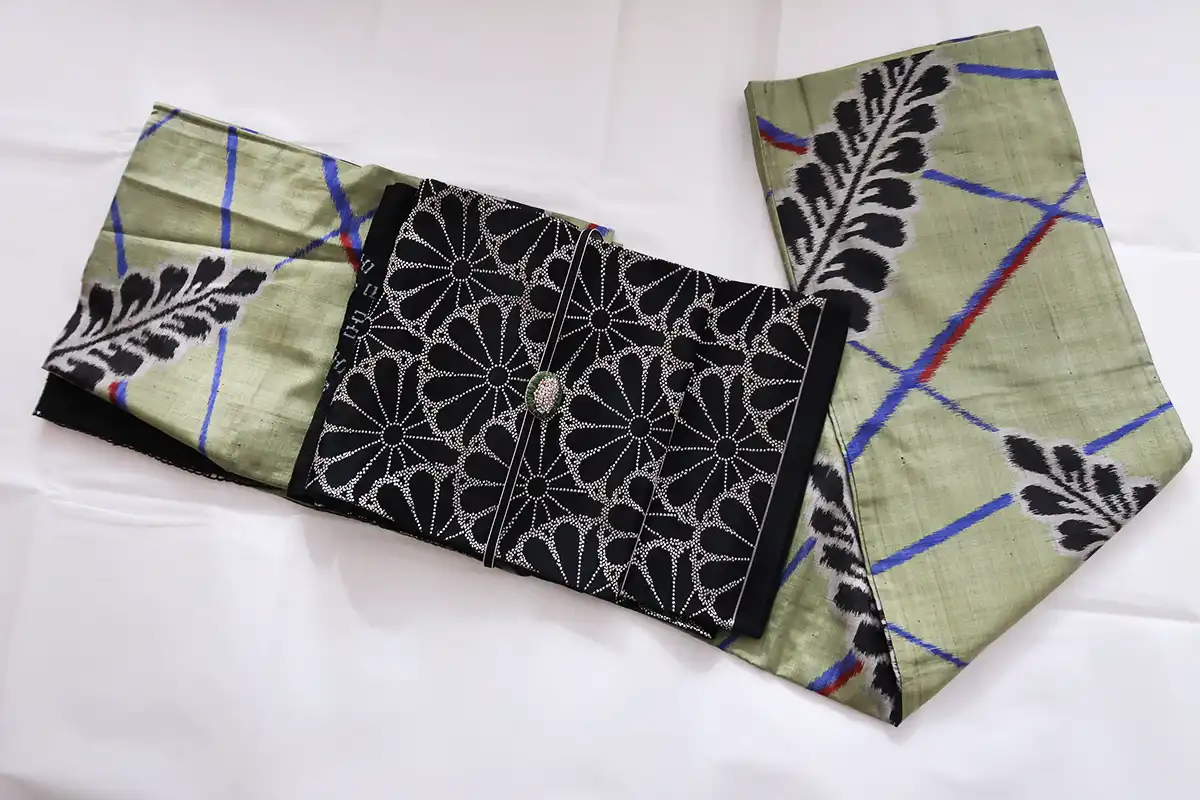 抹茶色の藤柄銘仙着物に黒地の菊柄帯を合わせたシックなコーデ