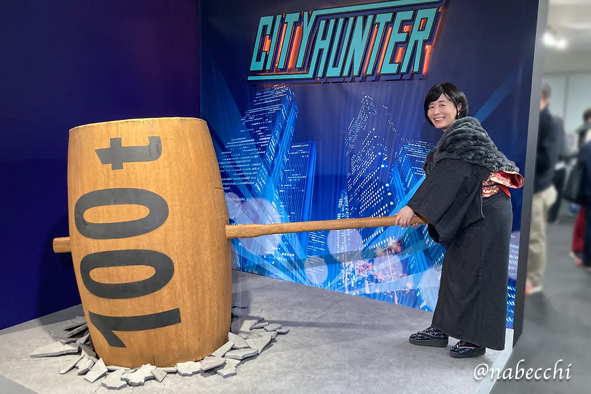 シティーハンター展の100tハンマーを持ち、楽しそうに構えるデニム着物姿の筆者
