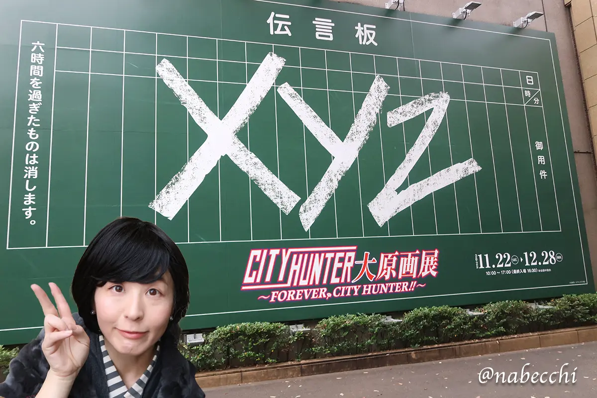 シティーハンター展入口の巨大なXYZ伝言板の前で、デニム着物姿でポーズをとる筆者