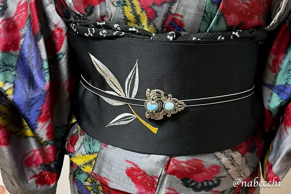 ターコイズ帯留めを主役にした黒帯コーデ。シンプルな帯まわりで石の色を引き立てている