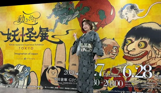 妖怪展の巨大スクリーン前で撮影。がしゃ髑髏の名古屋帯を締めた、黒大島紬のモノトーンお出かけコーデのメインビジュアル