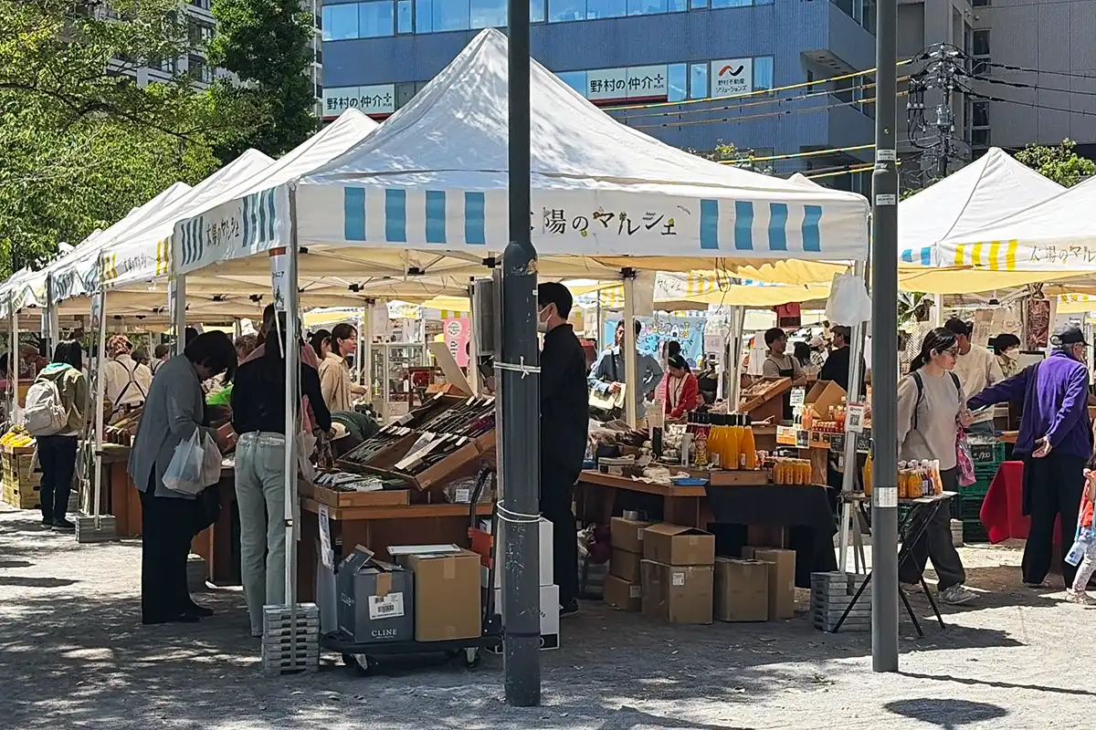太陽のマルシェの会場風景。白いテントが並び賑わう様子。