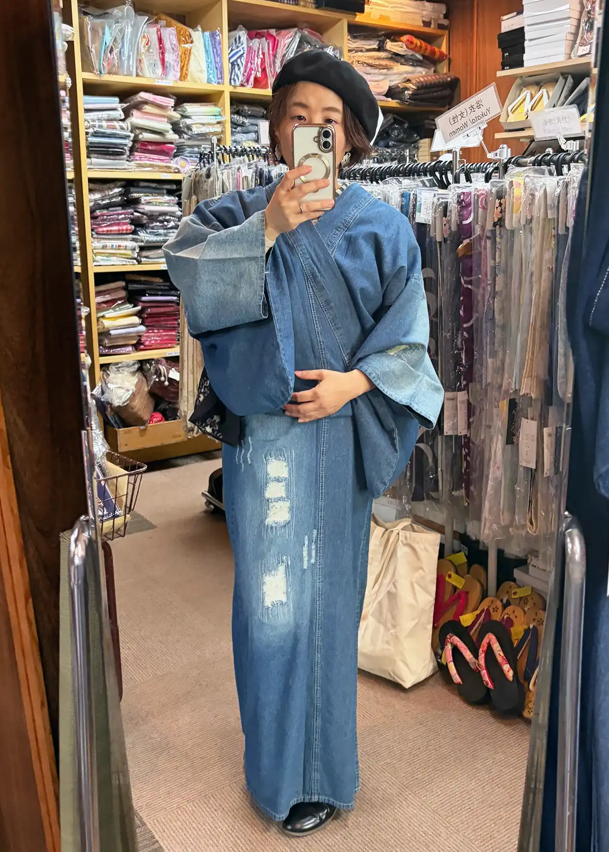 クラッシュ加工が入ったデニム着物を鏡の前で試着している女性の自撮り写真