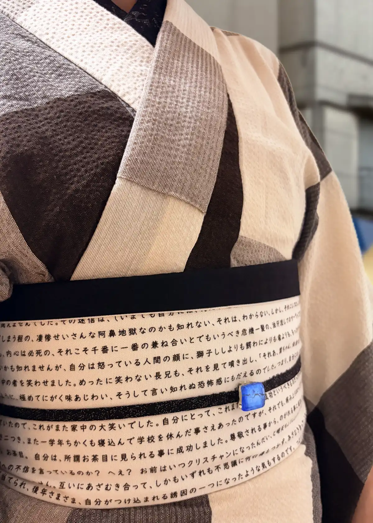 茶色チェックの阿波しじら着物に人間失格の半幅帯と青い帯留めを合わせたコーデ