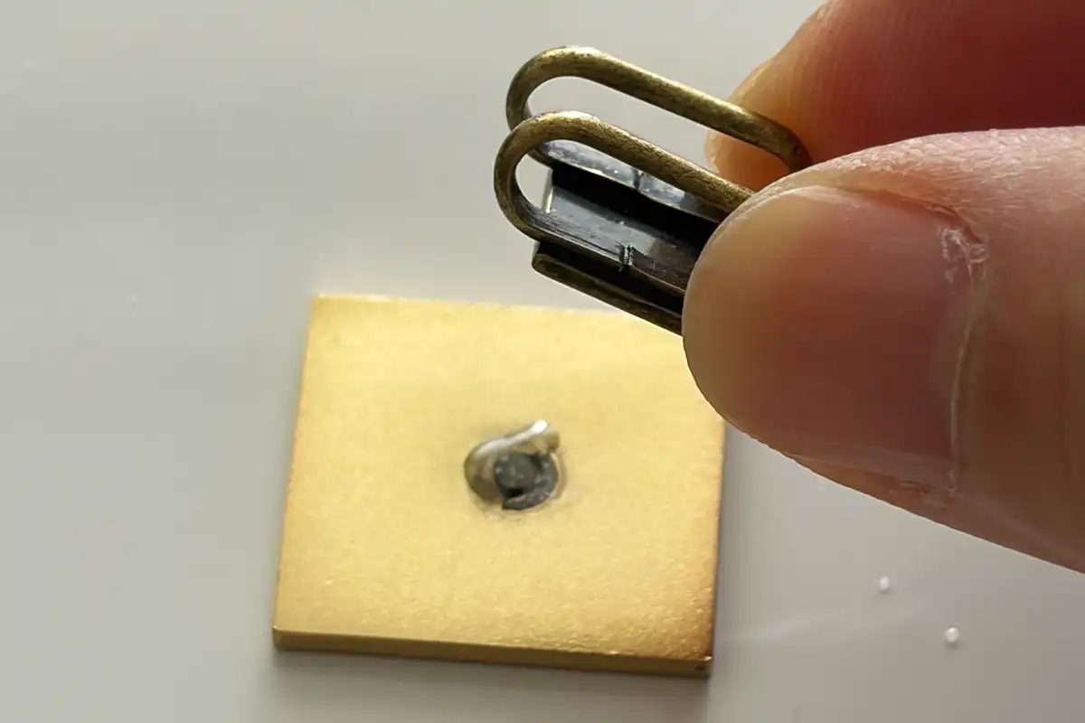 マジョリカタイルのピンバッジ裏面に三分紐用の極小帯留め金具を接着している工程