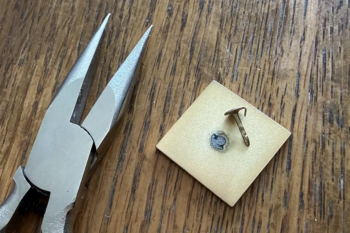 マジョリカタイルのピンバッジ裏面と、ピン金具を外すために使ったペンチ