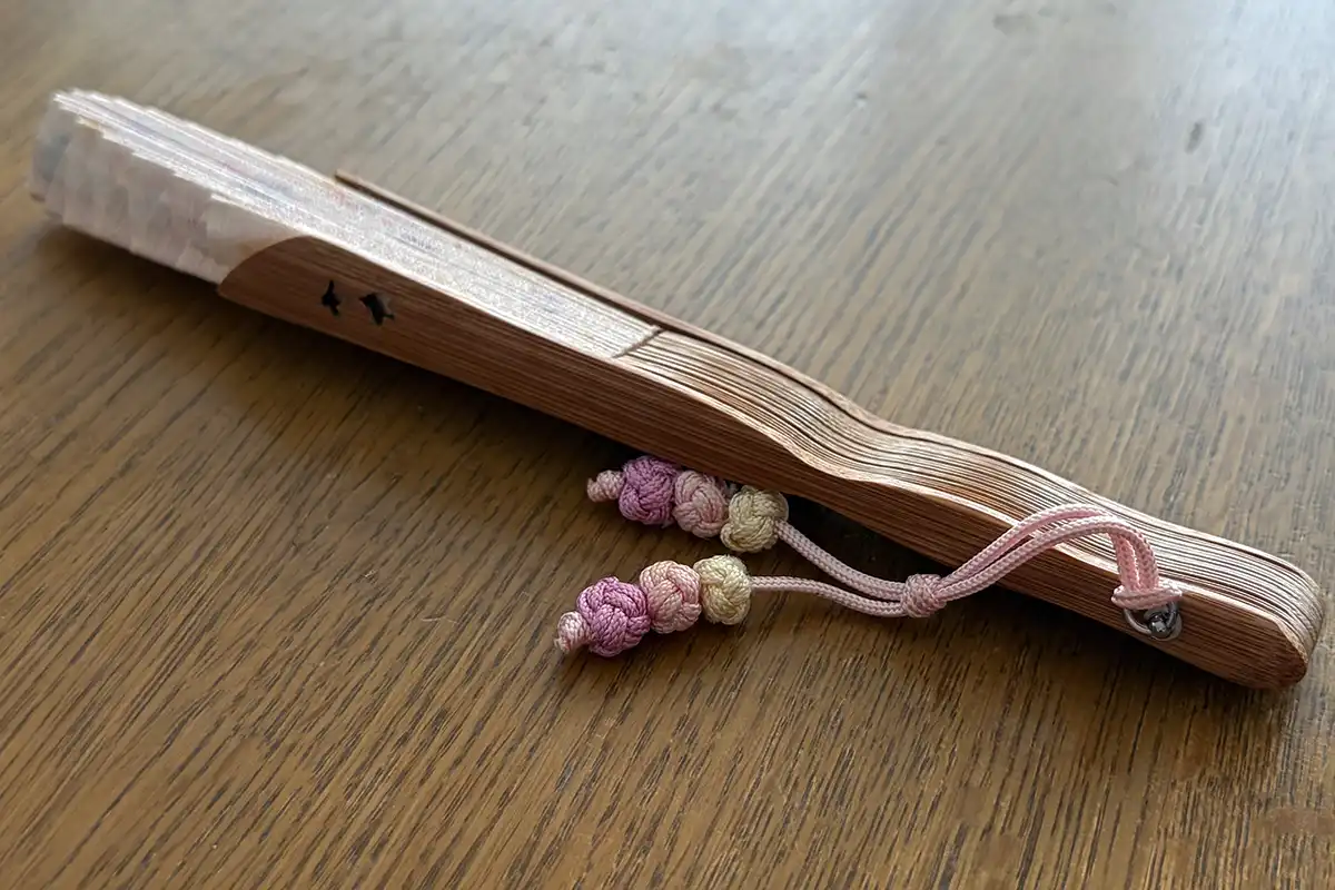 千鳥の透かしが入った扇骨とピンク系の房飾り