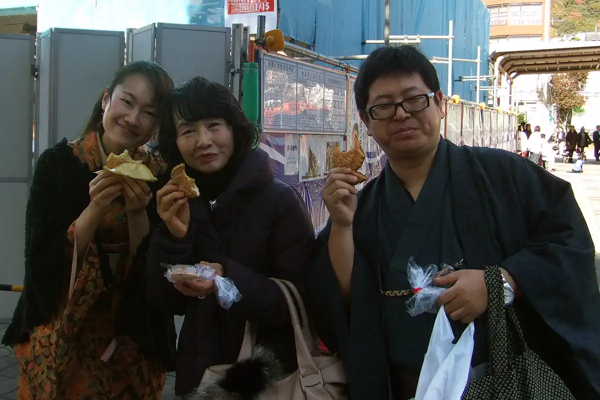 箕面駅前で鯛焼きを食べる着物姿のメンバー