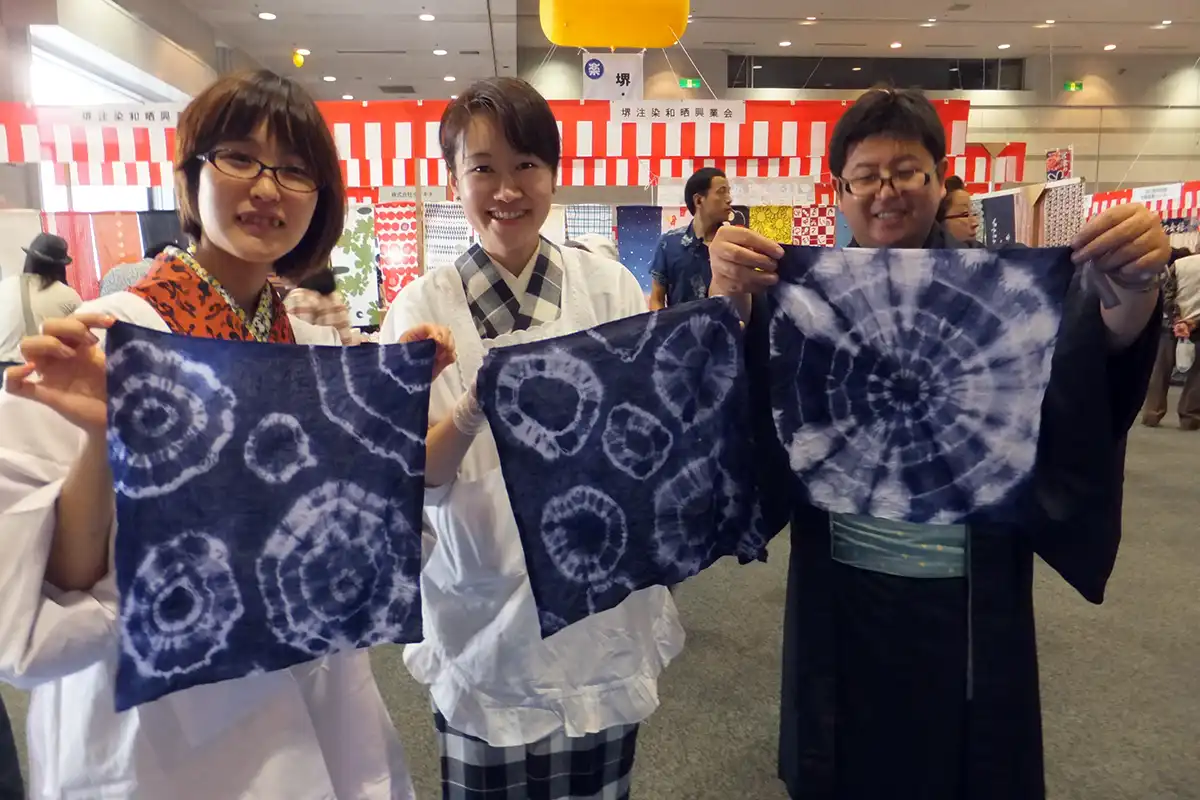 絞り染め体験で完成した藍染め作品を持つ参加者たち